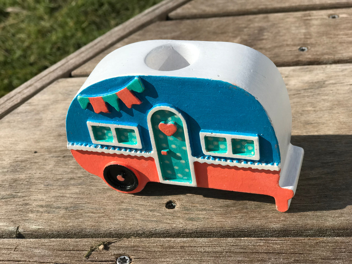 Top view of the ceramic campervan candle holder showing the recessed grey wheel detail and vibrant bunting accents under a glossy glaze
