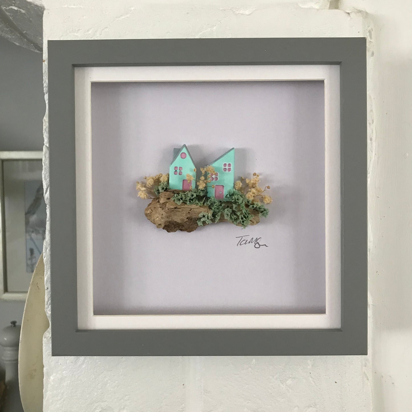 Miniature Turquoise Clay Houses Art – Framed Driftwood Scene with Wild Flowers (18x18cm)