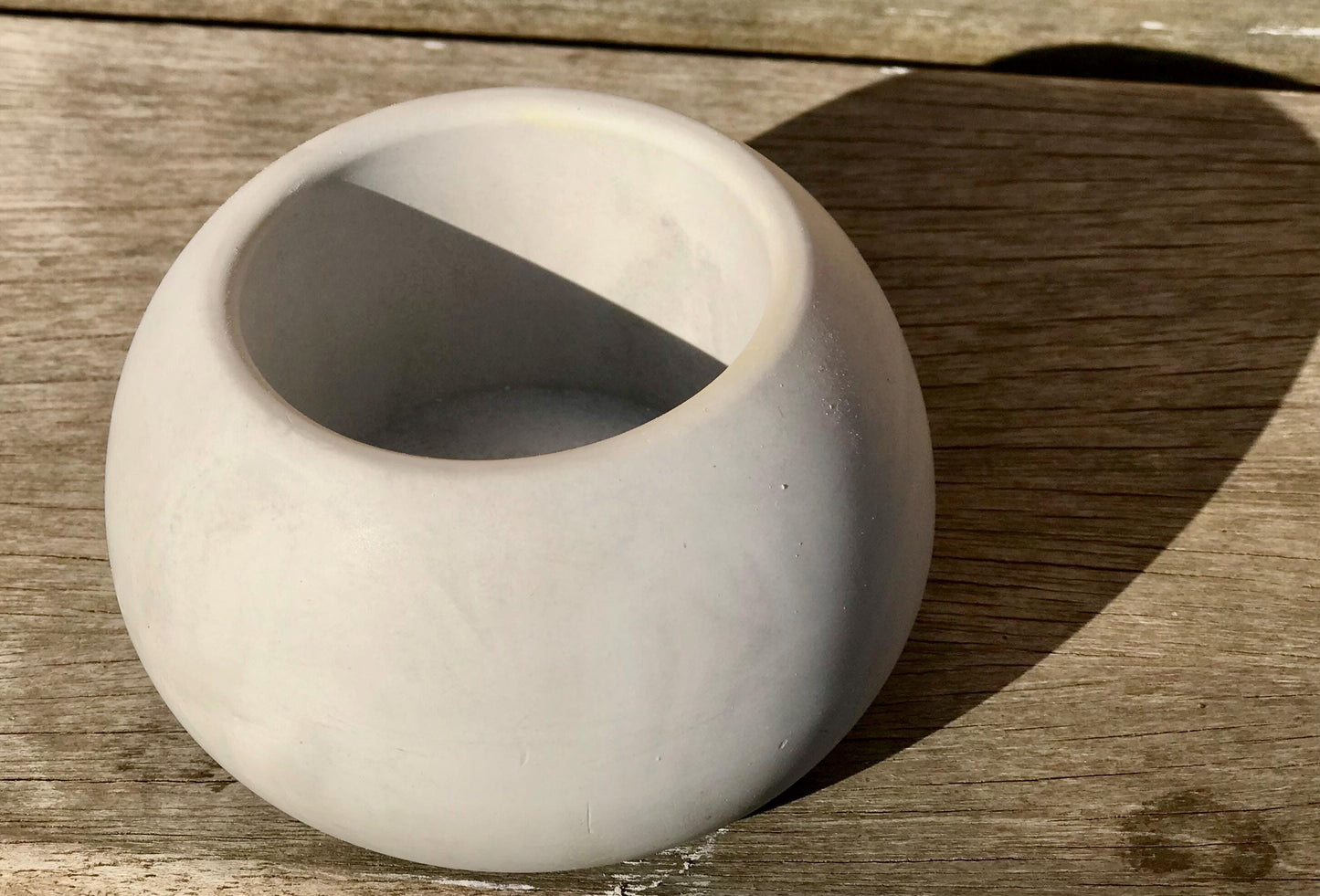 Cream sphere T-light holder side view showing recessed opening, handcast ceramic
