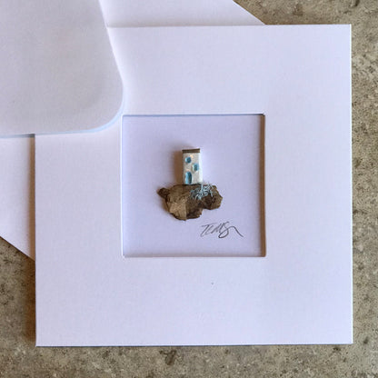 Little House card featuring a single handcrafted clay house on driftwood, framed in a 13.5 cm square aperture card.